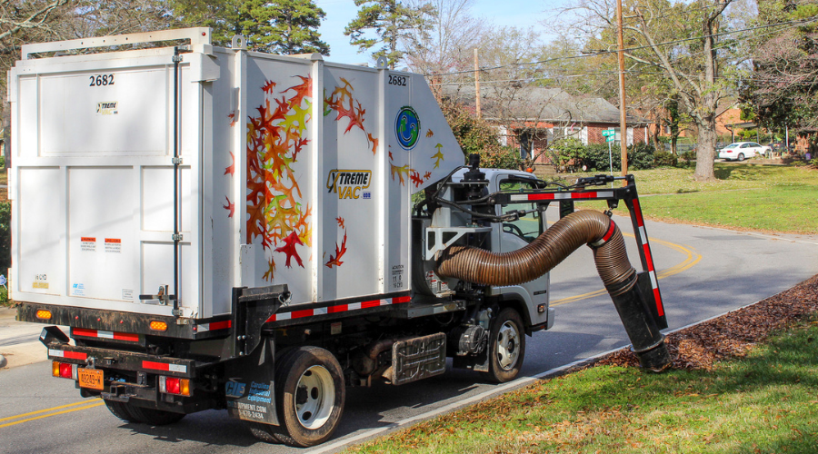 vacuum truck collects leaves at the curb 